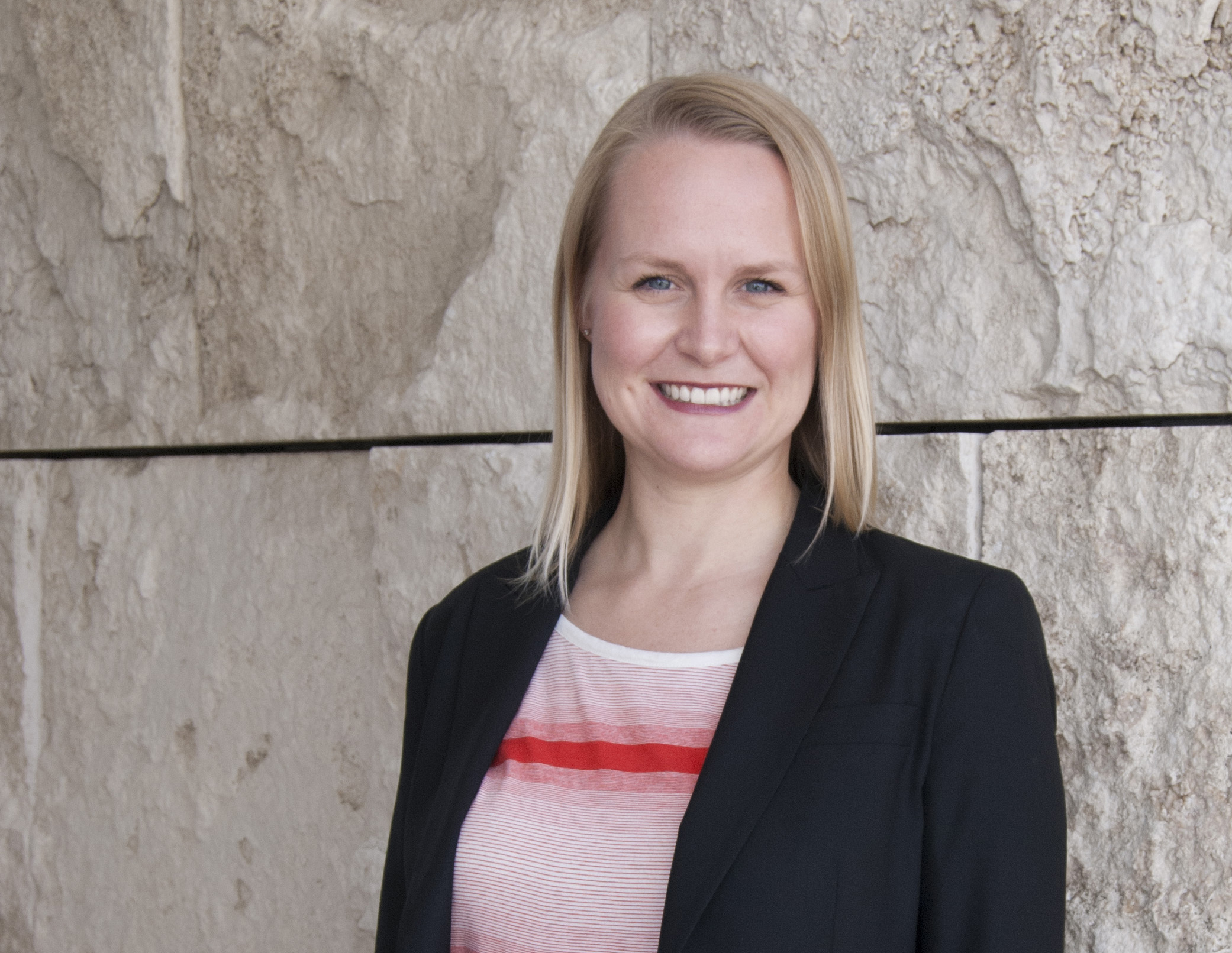 Headshot of woman smiling with short, blonde hair.